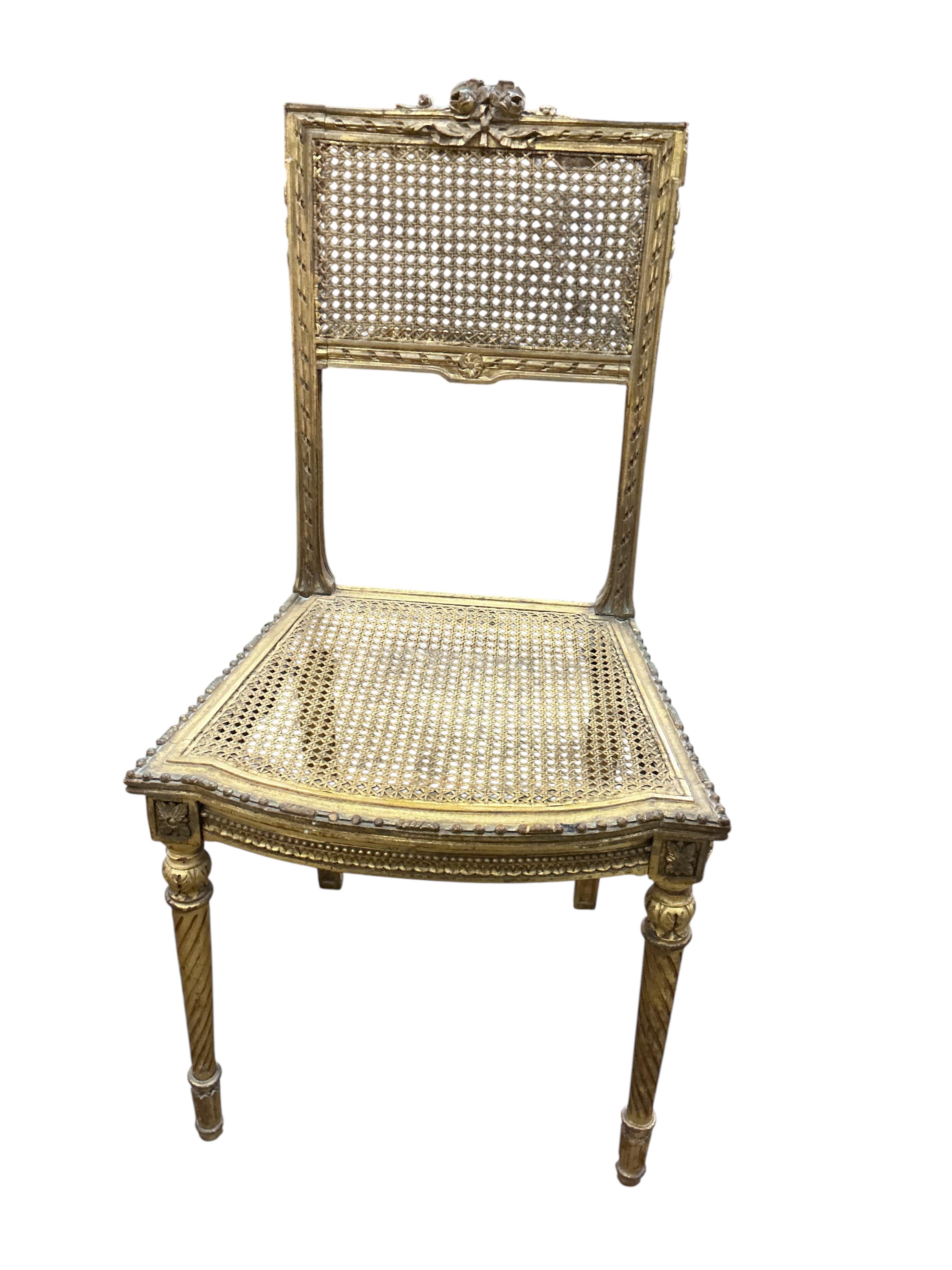A late 19th century French Louis XVI style open elbow chair with cane seat, a matching side chair and another giltwood side chair